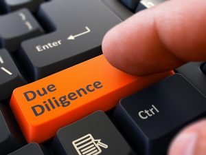 45139267 - due diligence - written on orange keyboard key. male hand presses button on black pc keyboard. closeup view. blurred background.